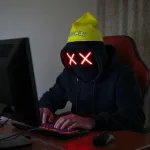 Computer hacker wearing a dunce cap hat