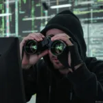 Hacker spying through binoculars