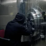 Hacker breaking into a locked bank safe