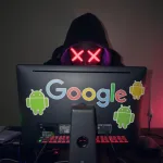 A hacker on a laptop with Google and Android stickers on it