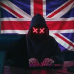 Computer hacker in front of a United Kingdom British flag