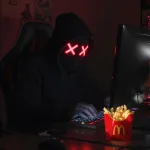 Computer hacker with McDonalds French Fries on his desk