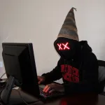Dumb hacker wearing a dunce cap