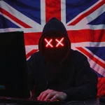 Computer hacker in front of a United Kingdom British flag