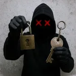 Computer hacker holding a large metal lock and key