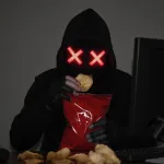 Hacker eating a snack food bag of potato chips