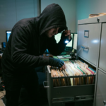 Computer hacker rummaging through filing cabinets of paper files records